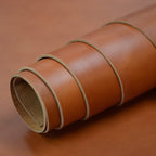 Rolled-up piece of brown leather on a brown background